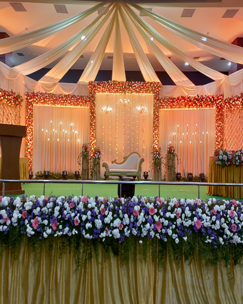 Elegant wedding stage with floral backdrop and warm lighting